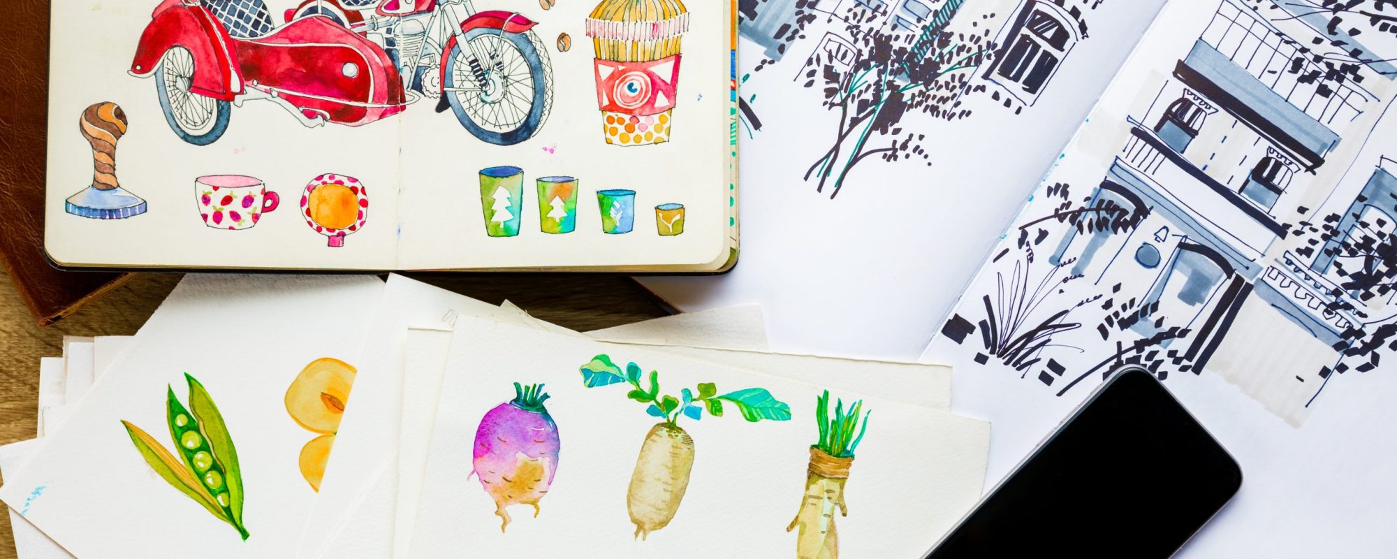 top view of watercolor drawings and smartphone